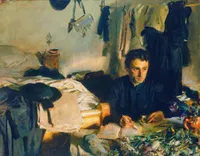 Oil painting of a dark-haired young man seated at a small desk in a cramped, sunlit room, writing intently in a book or letter. He wears a dark robe or coat and has an intense, weary gaze. The cluttered room around him features an unmade bed with white sheets, dark coats and a hat hanging from pegs on the wall, a washbasin and jug, and a vase or bundle of cut flowers and greenery spilling across the foreground table. Loose, impressionistic brushwork in muted greens, golds, and blacks. Signed 'John S. Sargent' in the upper left.