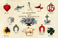 French illustrated card titled 'Le Langage des Porte-Bonheur' (The Language of Good Luck Charms), featuring fourteen labelled lucky symbols arranged around the title: a red heart charm (Amour / Love), a fish (Paix / Peace), a horn (Joie / Joy), a red shoe (Santé / Health), the number 13 in a circle (Longévité / Longevity), a dice (Gain / Gain), a bouquet of daisies and forget-me-nots at centre, an anchor (Espérance / Hope), a pansy flower (Souvenir / Memory), a horseshoe (Veine / Luck), a pig (Prospérité / Prosperity), a red horseshoe magnet (Argent / Money), and a four-leaf clover (Bonheur / Happiness).
